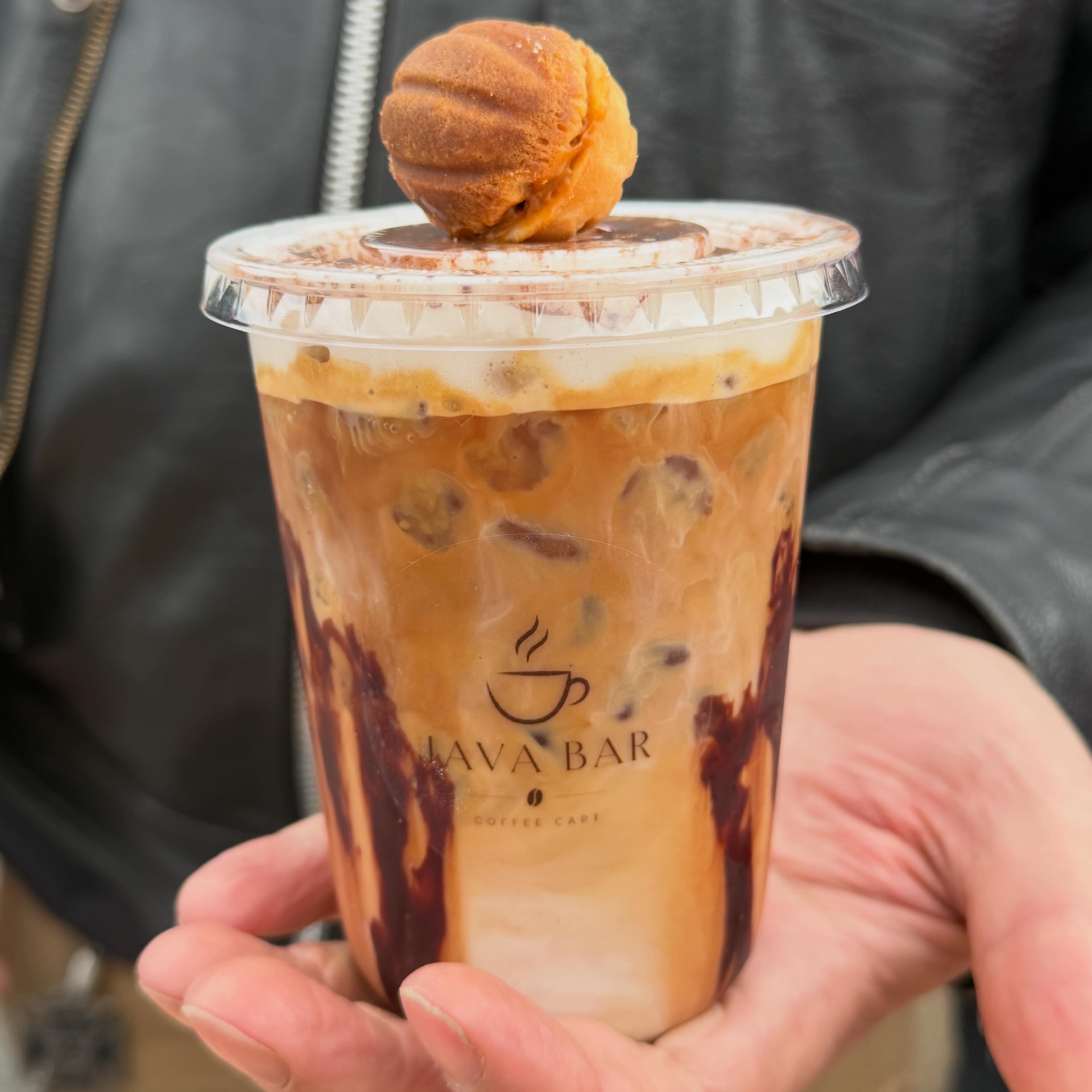 Iced latte topped with a mini donut